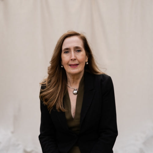 Woman wearing a black blazer against a plain background