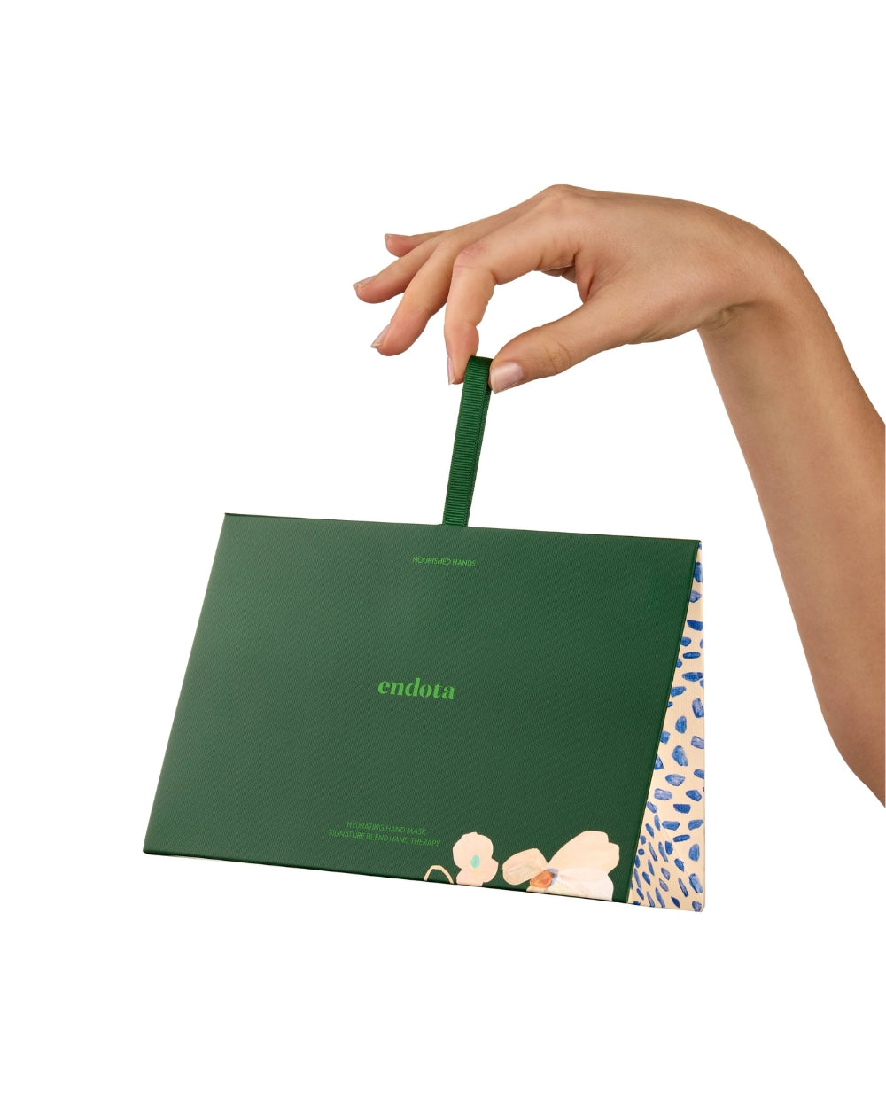 A hand holding a dark green endota gift box with a matching green handle, set against a plain white background.