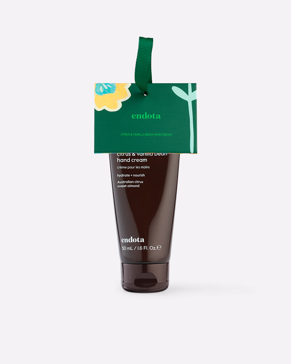 endota Citrus & Vanilla Bean Hand Cream in a dark brown squeeze tube with a green hanging tag, shown on a light gray background.