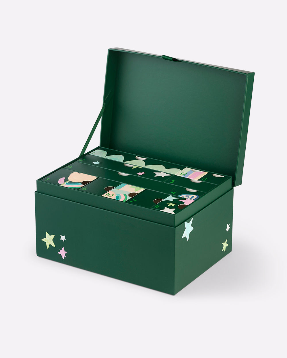 A dark green skincare advent gift box with an open lid, decorated with white stars and featuring illustrated compartments inside, shown on a light grey background.