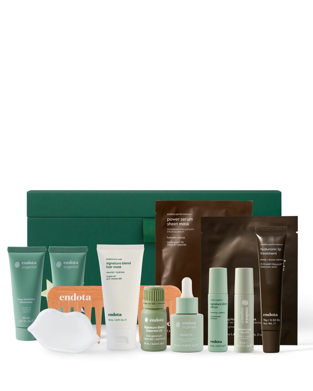 A skincare gift set from endota arranged in front of a dark green gift box on a white background. The set includes various tubes, bottles, and packets in sage green, white, and brown packaging.