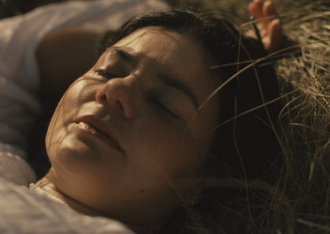 Person lying on grass with a close-up of their face